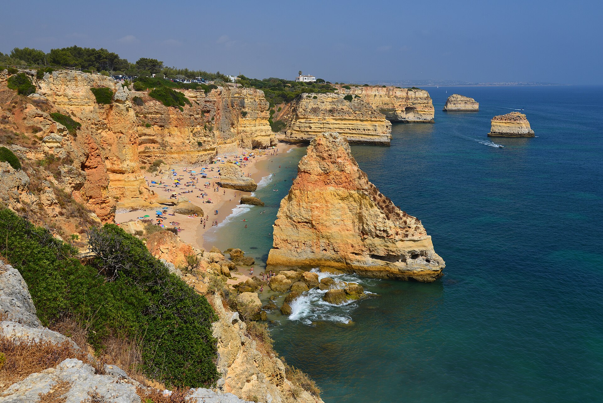 Golden limestone cliffs and a sea stack above turquoise water at Praia da Marinha, Algarve