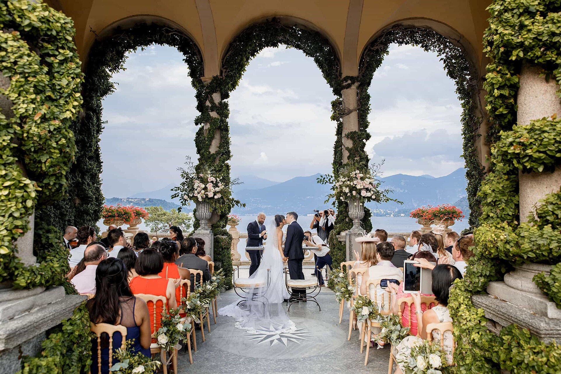 A wedding ceremony in the ivy-covered loggia of Villa del Balbianello, overlooking Lake Como
